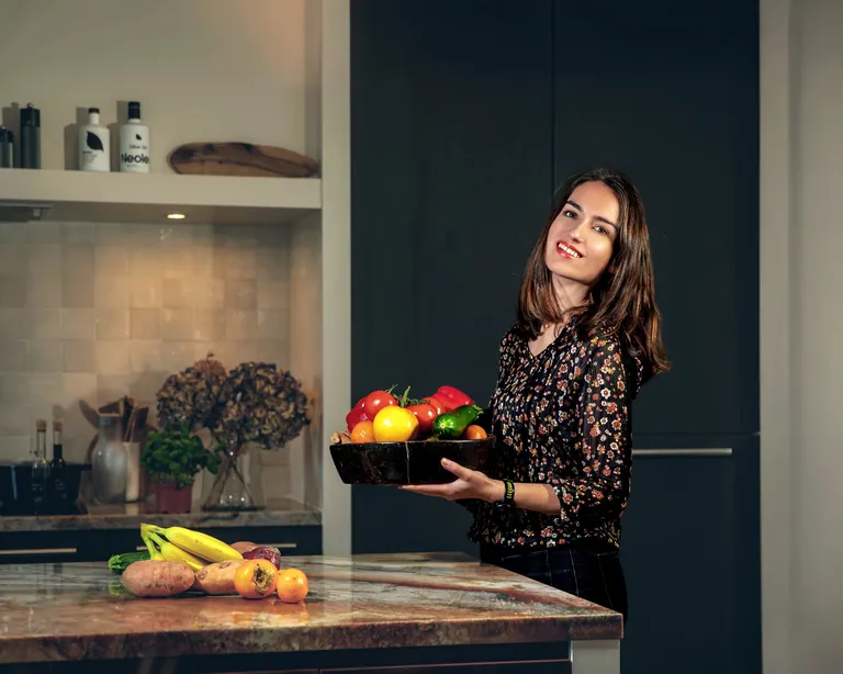 Esmée Borgts met een schaal verse groenten in haar keuken